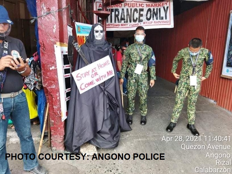 LOOK: Effigy ni ‘kamatayan’ inilagay sa palengke sa Angono, hawak ang karatulang “Stay at Home or Come with Me”